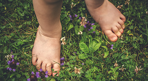 Pieds d'un enfant debout sur l'herbe